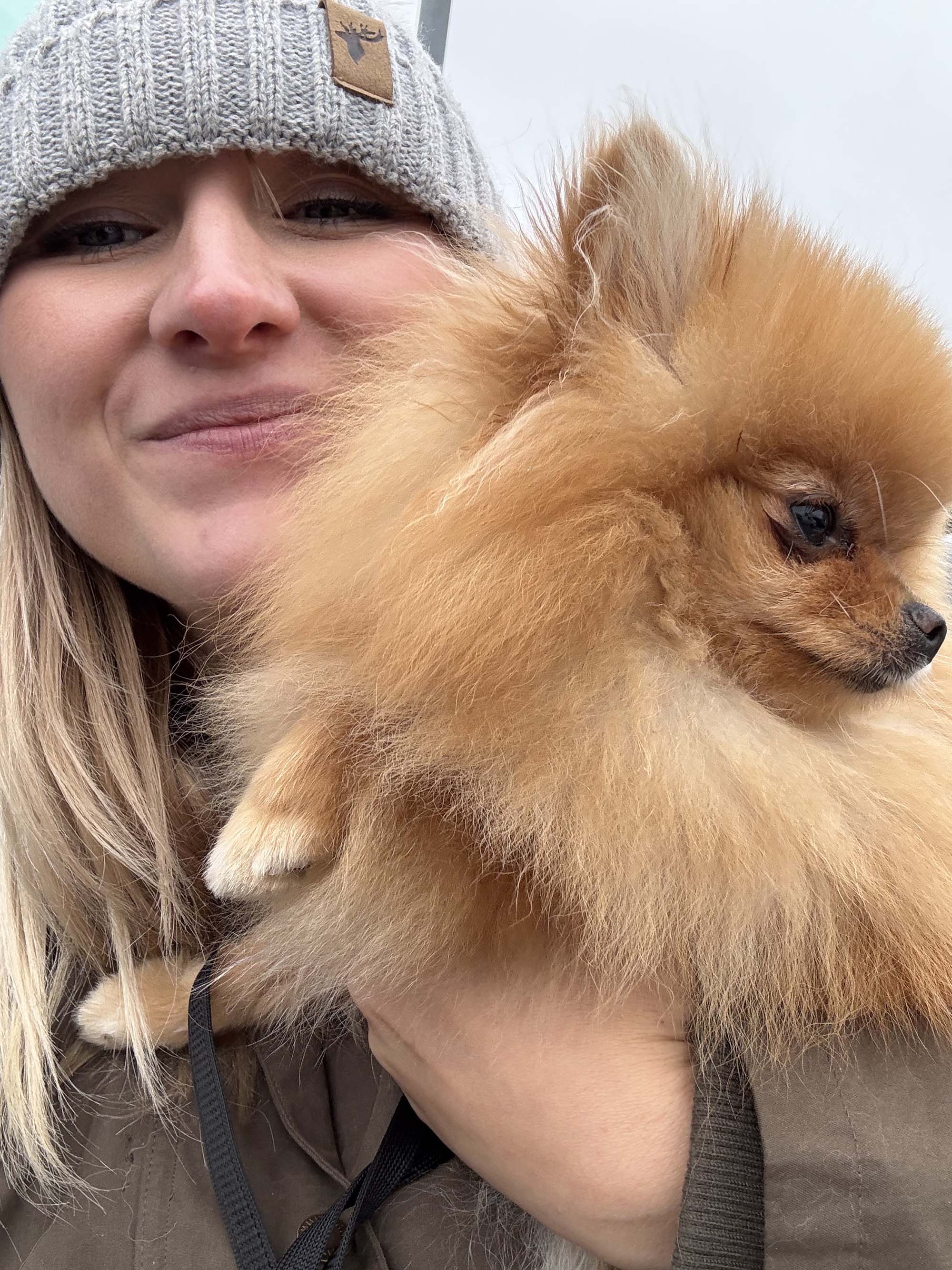 Close up of Lydia Harrison with small Pomeranian dog in Birmingham